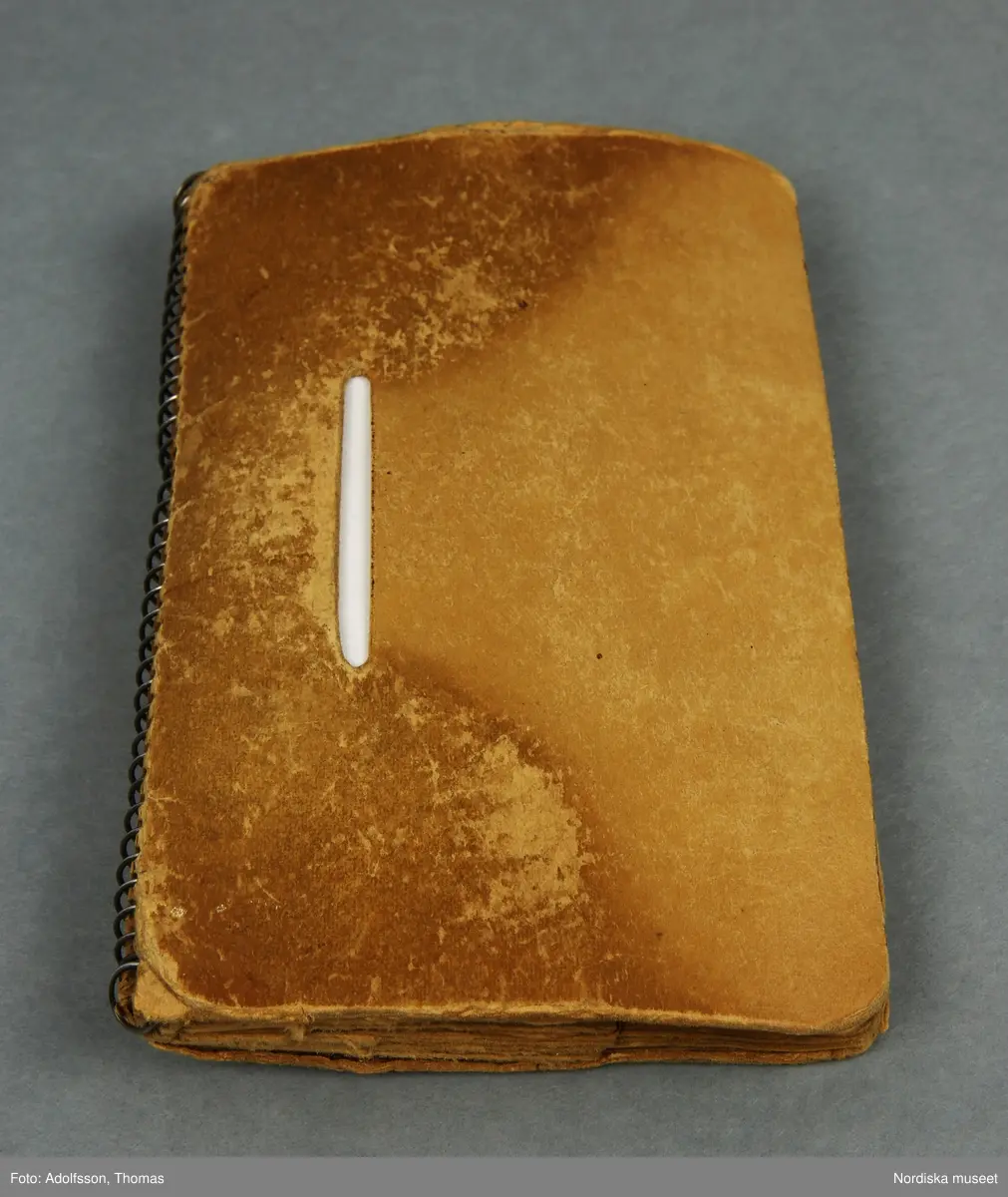 a) Plånbok av papp med spiralrygg av metall, för förvaring av ransoneringskort. I plånboken ligger b:1-51) 51 kort eller delar av ransoneringkort, c:1-7) 7 mindre fragment/rutor av ransoneringskort samt d:1-2) personkort och e) bilaga till personkort.
Givaren har bifogat f:1-9) kortare beskrivning av de respektive korten. Beskrivningarna förvaras i plånboken.
/Cecilia Hammarsten-Larsson 2019