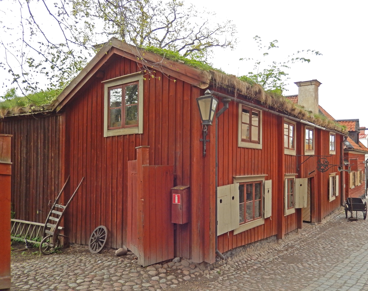 Kryddkramhandlarens hus är byggt i vinkel, timrat i två våningar samt klätt med stående locklistpanel. Fasaden är målad med röd slamfärg. Fönstersnickerierna är målade med linoljefärg i grått, fönsterbågarna i engelskt rött. Sadeltaket är klätt med torv. Byggnaden rymmer ett bokbinderi, en kryddbod med bodkammare i bottenvåningen samt en arbetarbostad, en gravörverkstad samt ett sadelmakeri på övervåningen.

Huset är troligen uppfört under 1700-talet. Huset stod på Bondegatan 50 på Södermalm i Stockholm när det revs 1929. Byggnaden återuppfördes på Skansen 1935.