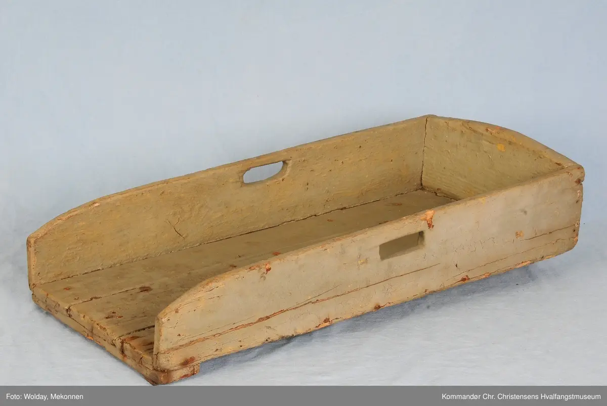 Rektangulært trau med bærehåndtak i sidene. Minkende høyde mot åpningen. Snekret kasse åpen i en ende.