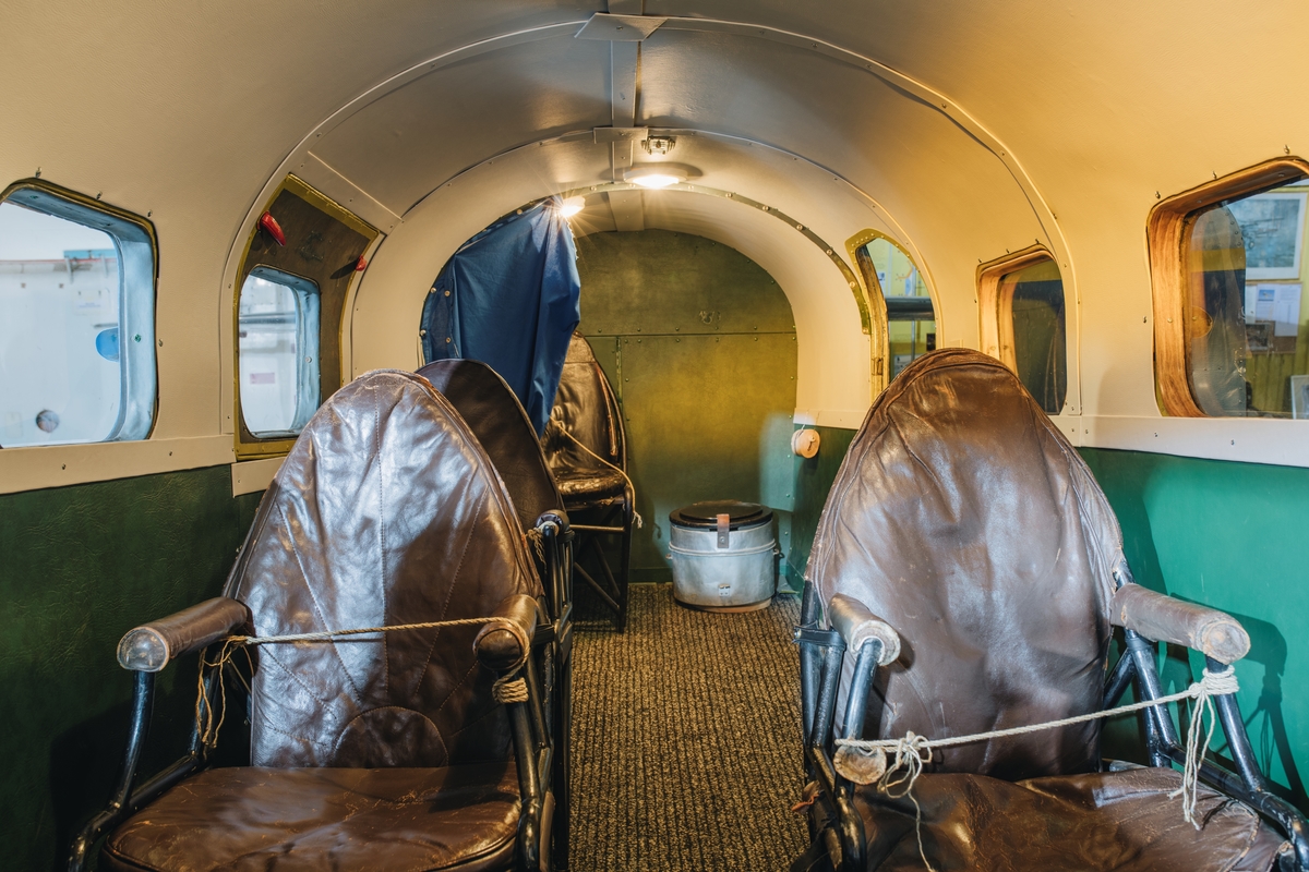 Flygplan av modellen Lockheed 12 Electra Junior. Propellerflygplan med metallren flygkropp och vingar, blå och gul dekor samt text: ”Airtaco AB”. Vänster vinge monterad, höger vinge ej monterad. Motorkåporna är till stor del ej original utan gjutna i plast. De passagerarstolar som är monterade är ej original, utan kommer från ett flygplan av typ DH 89 Dragon Rapide.