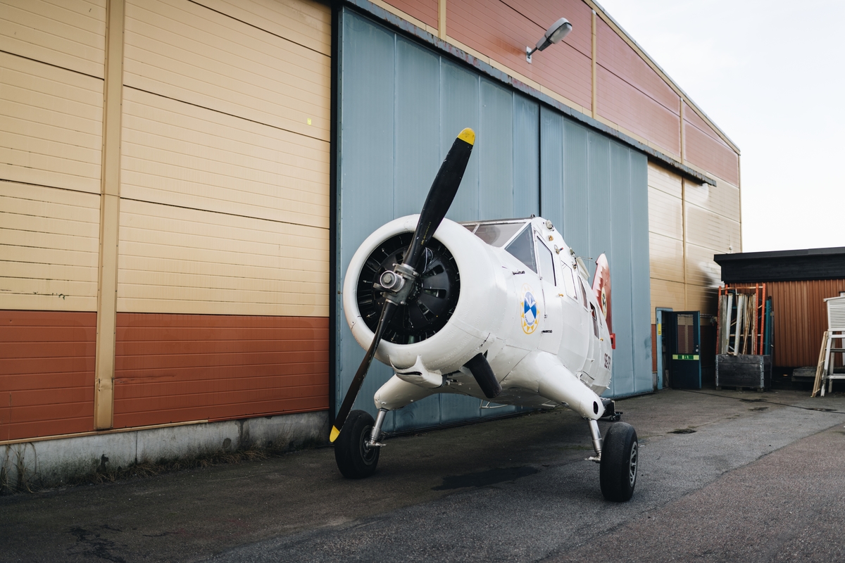 Flygplan av modell Noorduyn Norseman. Enmotorigt, högvingat propellerflygplan med fast landställ. Kan utrustas med hjul, skidor eller flottörer. Plats för två piloter side-by-side, och sex stolar i en täckt kabin. Flygkroppen utgörs av en svetsad stålrörsstomme och vingar av trä. Både flygkropp och vingar är dukklädda. Flygplanet är delvis demonterat. Vitmålat med röd dekor: "Norrlandsflyg".