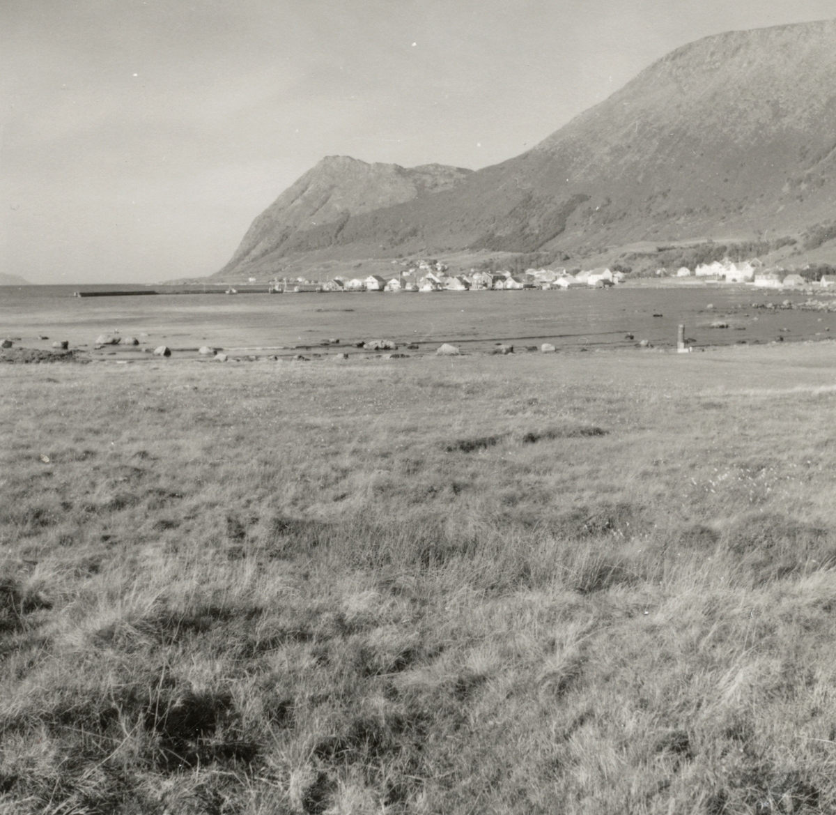 Prospektfotografi i serie fra sør-østsiden av Godøy ved havna. Her ligger Gøygarden, den gården som hadde det største fellestunet i Borgund og Giske.