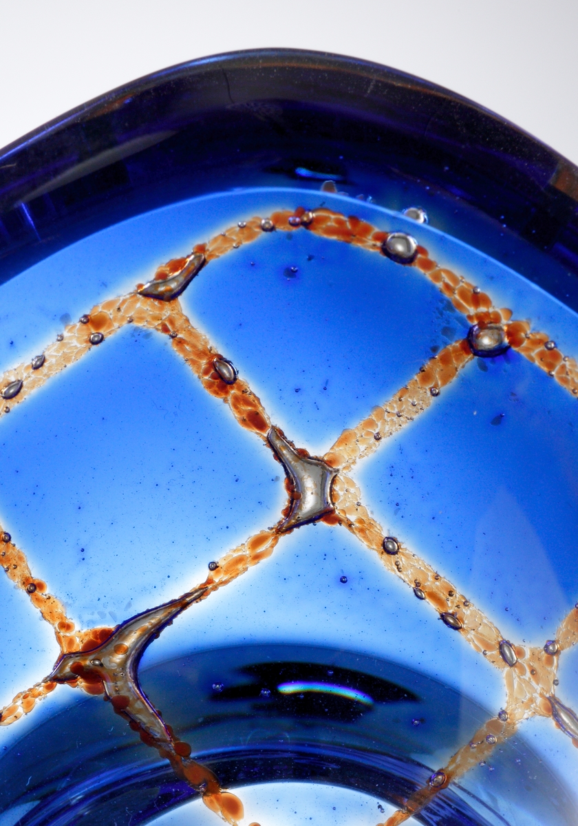 Design: Sven Palmqvist. Mindre, oval, ravenna-skål nr 6208 med klack. Mönster i blått och brunt. Konstnär Sven Palmqvist.