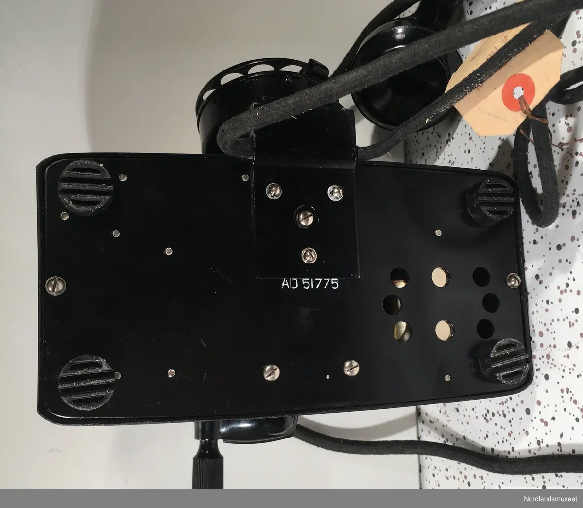 Telefonapparat med sveiv og nummerskive
Kombimodell, som kan benyttes i manuelt og automatisk telefonnett.
Bunnplate merket med AD 51775
Merkelapp på ledning merket med: "2. nov 1951" og "MEURICE BRUXELLES"
Produsent er noe usikker.