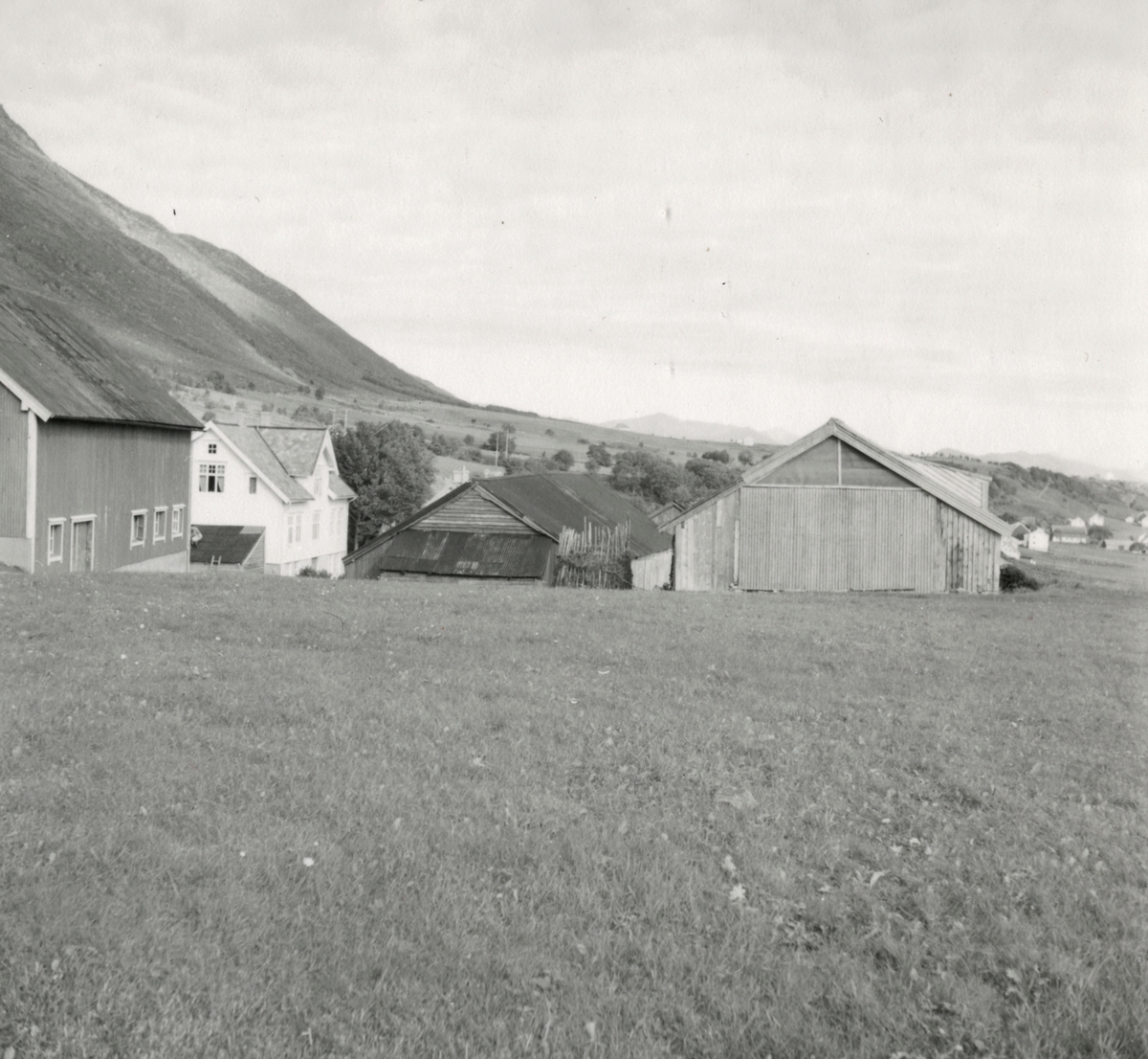 Prospektfotografi av et gårdsbruk med flere driftsbygninger på Godøya.