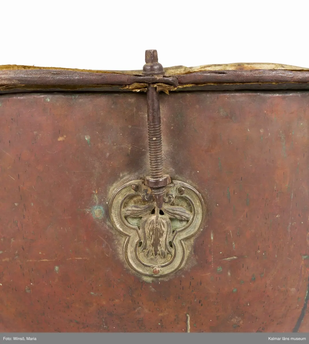 KLM 14939. Puka. Av koppar med beslag av järn och skinn på ovansidan. Står på tre korta ben formade som öglor. På utsidan skruvar och beslag formade som tulpaner. Försedd med Stålhammarska vapnet. Par med KLM 14940. Har eventuellt använts tillsammans med pukstockar KLM 14850-51.
