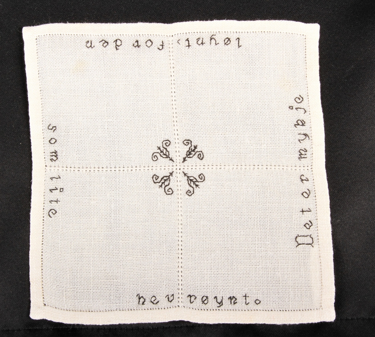Natur bunn med svart dekor, brodert korsting, hullsøm og attersting. Border, tekst og blomster.