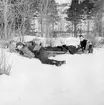 Soldater tar skydd från fientligt flyg under transport av skadad på räddningsbår vid sjukvårdsövning i fält vid F 11 Södermanlands flygflottilj, 1945. 

Vintertid.

Ur fotoalbum 