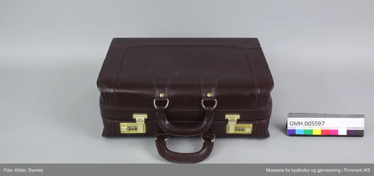 Den brune  dokumentkoffert av skinn har to håndtak og lukkes med to lås med tallkombinasjon. Innvendig er den utkledd med grå velourstoff. En klaffe i midten fungerer som romdeler og har tre store og to små lommer samt en holder for skriveredskaper. 