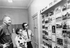 Kanslihuset, mitten av 1970-talet

En permanent fotoutställning i kanslihusets entrehall bestående av två glasskåp med belysning. 
Foto, text och montering Evert Wahlberg.

I skåpet på bilden visas bilder från heden i Malmköping.
Det andra skåpet, till höger utanför bild, visar bilder från regementets verksamhet i Strängnäs.

Bilderna betraktas av fanjunkare Erhard Isaacson, kanslist Gun-Britt Svensson och en värnpliktig soldat.