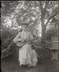 En dam som spelar gitarr, ca 1910.