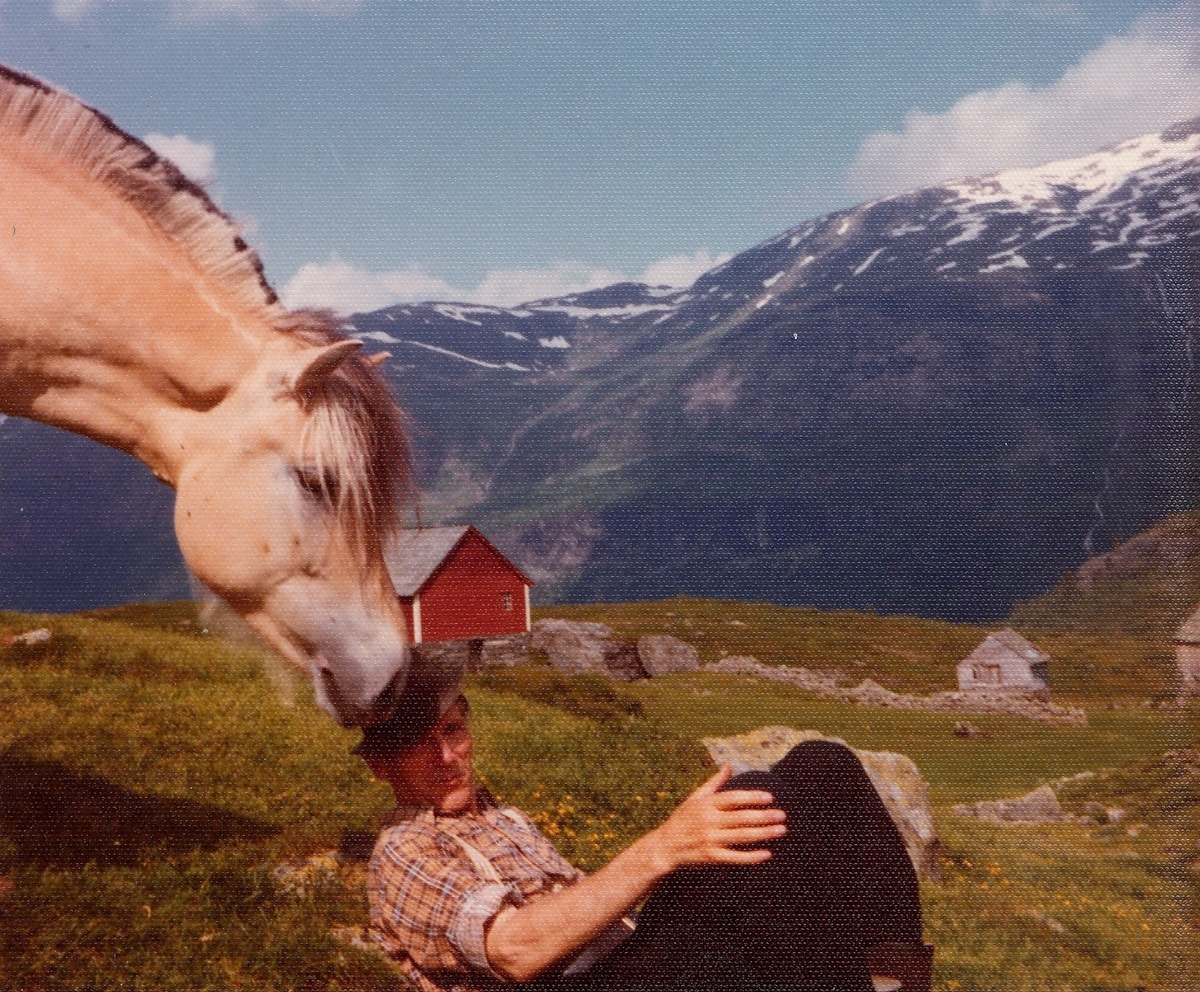 Fotografi av Olav H. Hauge saman med ein hest. Biletet er truleg teke på Jonstøl, den 17. juli 1975. I dagboka til Hauge står det denne dagen: "Sol. Fint. Til Kristinuten. Gjekk yver Ljono, Gaarhovden, Espeskòrane, Jonstøl. Kristinuten er 901 m. Fint og storslege utsyn yver bygdi og fjorden utyver; ser inn i Skrulen." (1) Fotografen er ukjend. Biletet vart skanna hos Bodil Cappelen i 2012, og er i Olav H. Hauge-senterets eige. Skanning og innhenting av informasjon vart utført av Eirik Bergesen Dalen.

Kjelde:
(1) Hauge, O.H. (2000) Olav H. Hauge Dagbok 1924-1994, fjerde bandet, side 265
