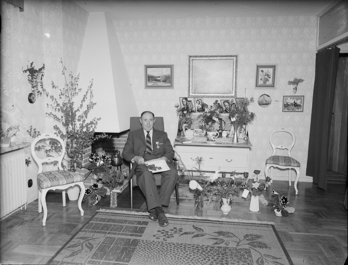 Sigfrid Lundström i bostadsmiljö omgiven av blommor, Östhammar, Uppland