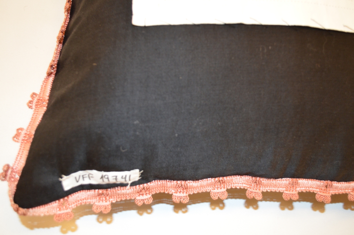 Pute. På framside vove i ull, kypertbinding. Broderi i ull.
Bakside: vove i  ull. Reparert med linstoff.