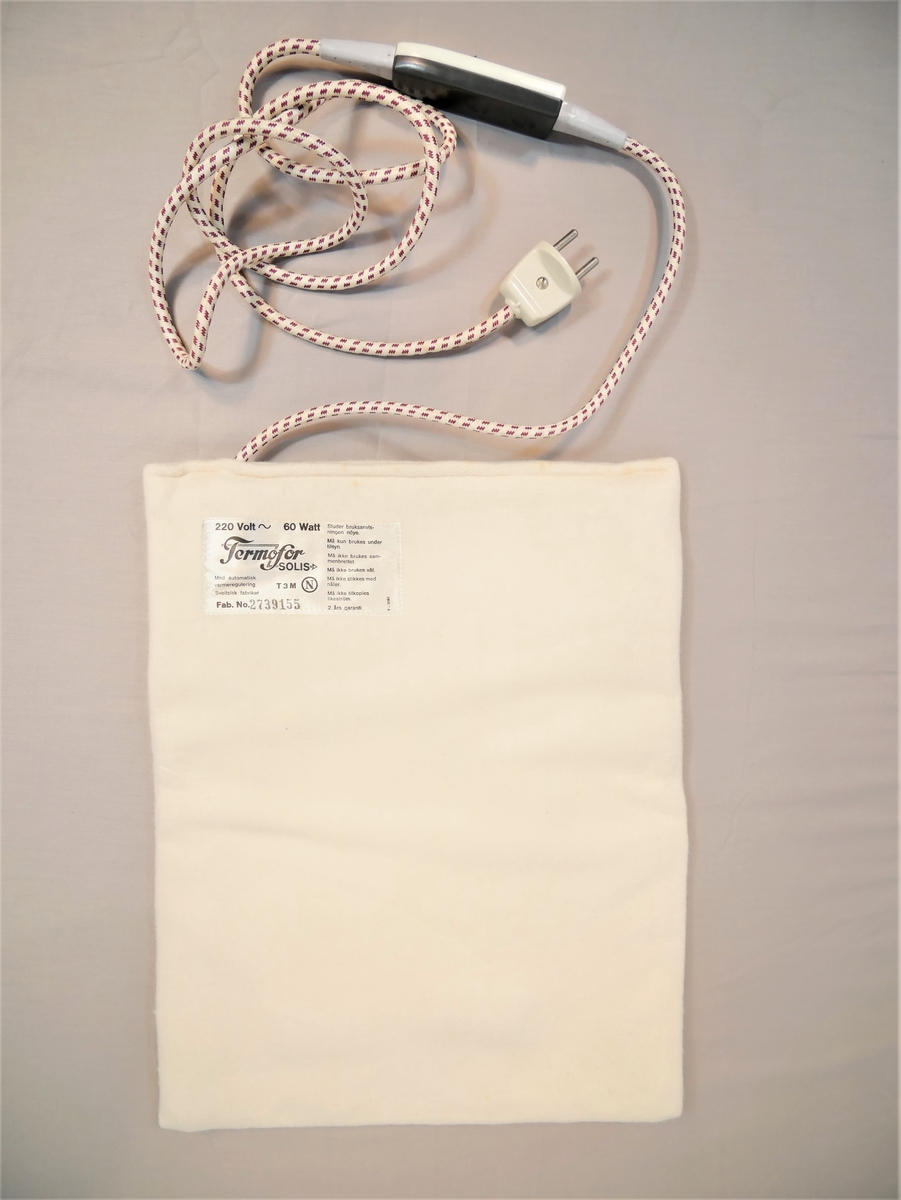 Flat pute med innsydd elektrisk kabel, ledning med brytar og støpsel.
Lerretstrekk utanpå.
