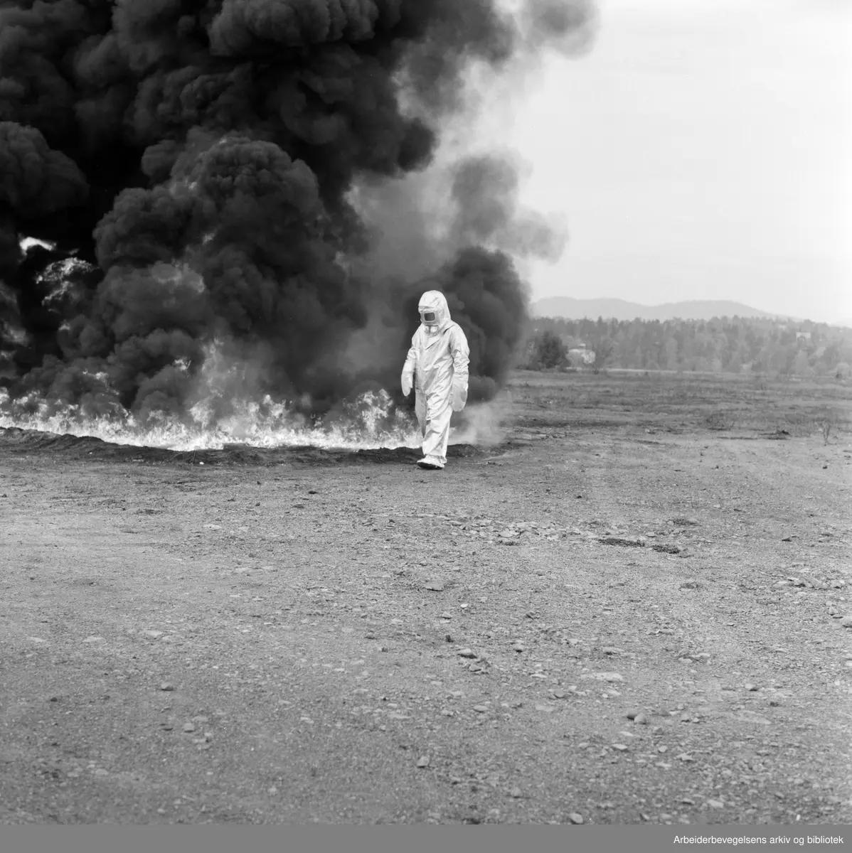 Brannvesenet demonstrerer flammesikre drakter på Fornebu flyplass. Oktober 1959..