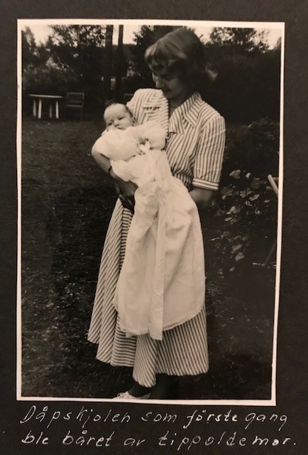 Dåpskjole med underkjole og belte.
Kjolen har rund hals med løpegang og knytesnor. Hele kjolen er klippet i ett stykke. skjøtt stoff på det ene ermet. Blondepynt i alle åpninger.  
Underkjolen er klippet i ett stykke. Rynket i halsen. Splitt bak med knepping øverst.
Bredt bånd der alle dåpsbarnas navn er brodert med henholdsvis blå og rosa skrift.