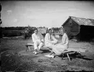 Josef, Sara och Tyra Edhlund sitter på en bänk, Östhammar, Uppland