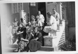 Tolv unge jenter sittende i trapp. Trolig 1930-tall.