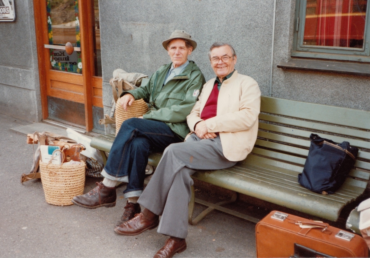 Fotografi av Olav H. Hauge og tyskaren Halle-Heinemann. I dagboka til Hauge står det den 11. august 1982: "-Ei veninne til Lotte Thiis, halvsyster til Bodil, kom og vilde helsa på oss. Ho er gift med ein tyskar og bur i Bremen. ... Mannen stakkar, var radt nedfor. Bodil fylgde med til Voss, og han køyrde attende til hotellet." (1) Fotografen er truleg Bodil Cappelen. Biletet vart skanna hos Bodil Cappelen i 2012, og er i Olav H. Hauge-senterets eige. Skanning og innhenting av informasjon vart utført av Eirik Bergesen Dalen.

Kjelde:
(1) Hauge, O.H. (2000) Olav H. Hauge Dagbok 1924-1994, femte bandet, side 24