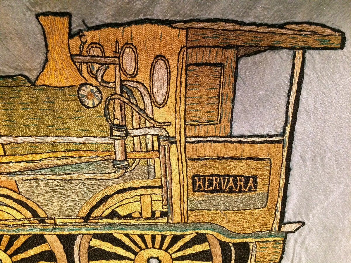 Rektangulär fackföreningsfana av blått broderat siden, för en järnvägsmannaförening i Malmö.
I mitten syns ångloket SJ Cb 339 Hervara, under detta ett bevingat hjul, en hjulaxel, samt ett arrangemang av verktyg och växtrankor.
Text i gult : "Personalen vid S.J. verkstad Malmö 1888 Arbete Enighet". Fanan är broderad i guld, svart och bruna nyanser med ett lok på mitten och eklöv i hörnen. Broderierna är utförda i stjälksöm och schattérsöm, vissa partier är även applicerade. Fanan har blågula fransar i kanterna.

Fanan är mycket blekt på den sidan som har legat uppåt i monter. Se sista bilden för jämförelse med undersidan.