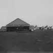 Hangar på Bulltofta flygstation under flygdag den 5 september 1926. Framför hangaren står ett flygplan.