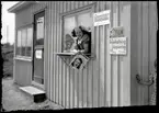 Kioskbiträde tittar ut ur kiosken