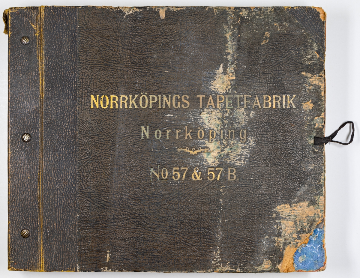 Tryckt tapetkatalog från Norrköpings tapetfabrik. Bruna hårda pärmar, brun rygg. Text i på pärmens framsida: "Norrköpings tapetfabrik No. 57 & 57B". innehåller prov på arsenikfria tapeter och bårder.