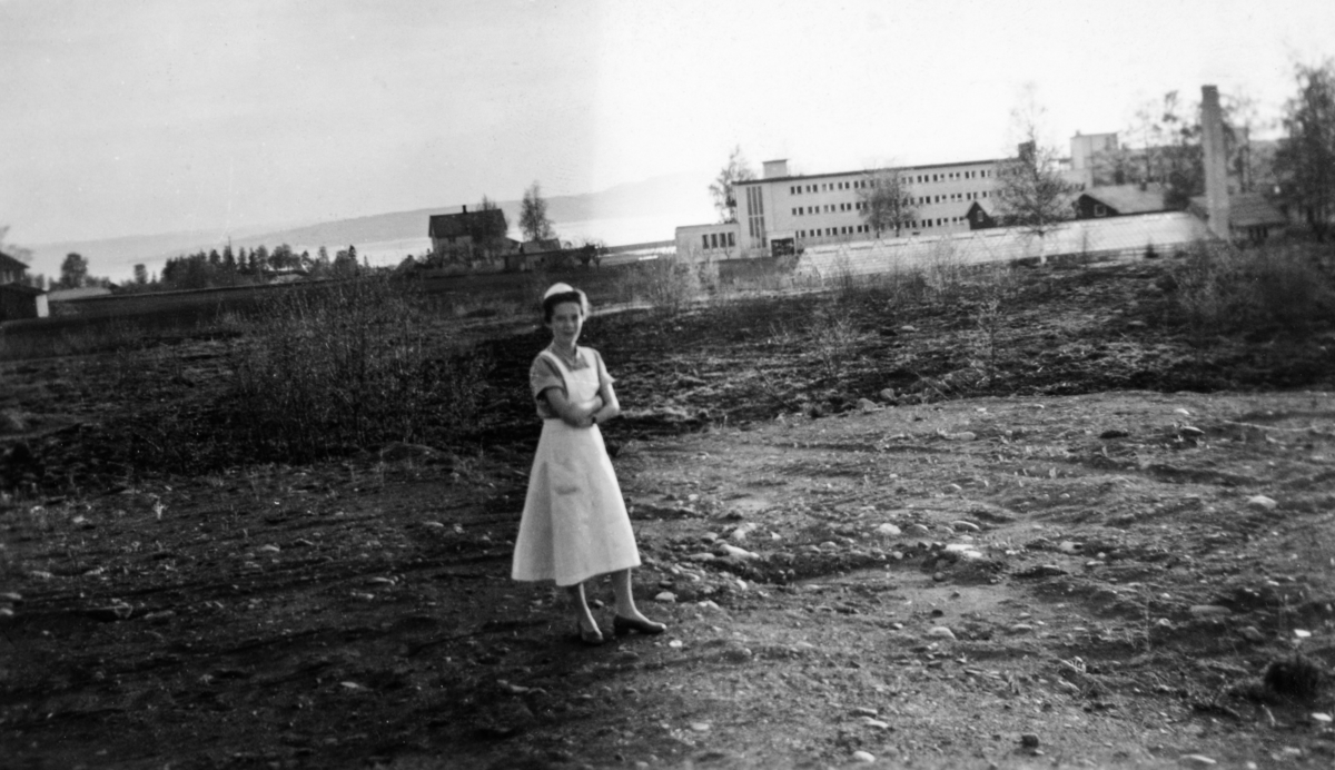 Elisabeth Johansen f. 1932, utenfor "Søsterboligen" Østlandske vanførehjem i bakgrunnen hvor hun arbeidet.
