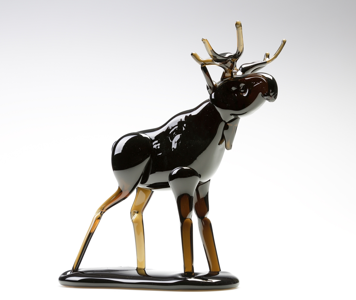 Skulptur. Formgiven av Nils Nilsson. Tillverkad av Joachim Nilsson. 
Följande text finns på ett reklamblad fasthäftat på registerkortet: "I slutet av 1940-talet började mästaren Nils Nilsson på sin fritid att tillverka glasälgar, som presenter till sina jaktkamrater. Älgen blev populär och efterfrågan ökade och Nils tog svärfar Harald (mästare på Berghems Glasbruk) till hjälp och på lördagseftermiddagarna efter arbetets slut träffades de i Berghem för att tillverka älgar. 
Älgen blev sedan ett signum för Nils och följde med honom från bruk till bruk. (Åseda, Eneryda, Hyllinge, Älghult m. fl.) När sonsonen Joachim 1985 började på glasbruk var farfar Nils redan pensionär, något som inte hindrade honom från att varje dag besöka bruket och ibland tillverka en älg. Joachim följde med stort intresse farfars skickliga arbete och snart prövade han sin första älg. Inget mästerverk precis - men den finns bevarad!!.
 I april 1995 startade Joachim tillsammans med bröderna Jesper och Jacob produktionen på anrika Gullaskrufs Glasbruk, som då legat nere en tid. Idag tilllverkar Joachim med hjälp av Jesper glasälgar med en elegans och hantverksskicklighet som farfar Nils skulle ha varit stolt över. Familjetraditionen lever vidare. Glasälgarna från Gullaskruf är signerade och numrerade".
Beskrivning: Älgtjur, friblåst med påklipp.
Färg: Brun.
Inskrivet i huvudkatalogen tidigast 1996.
Funktion: Prydnadfigur i form av en älgtjur.