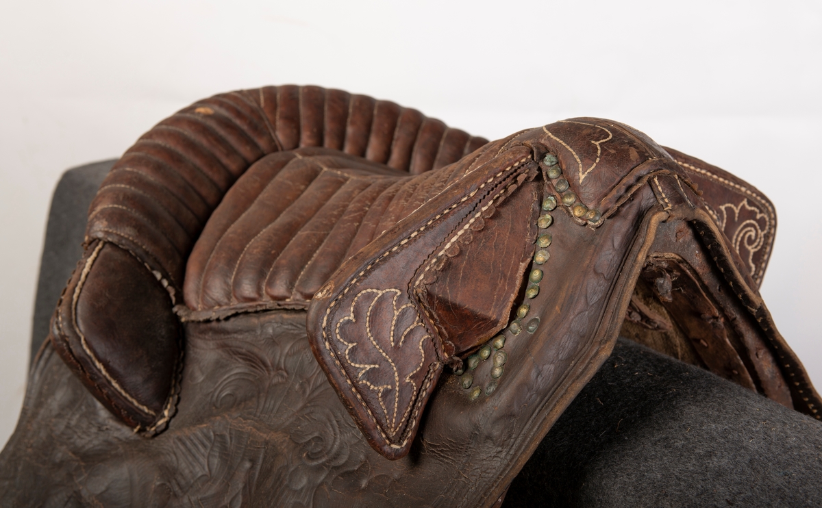 Lærtrukket sadel fra 1778. Initialene ONS brodert. Kapper med preget lær. 