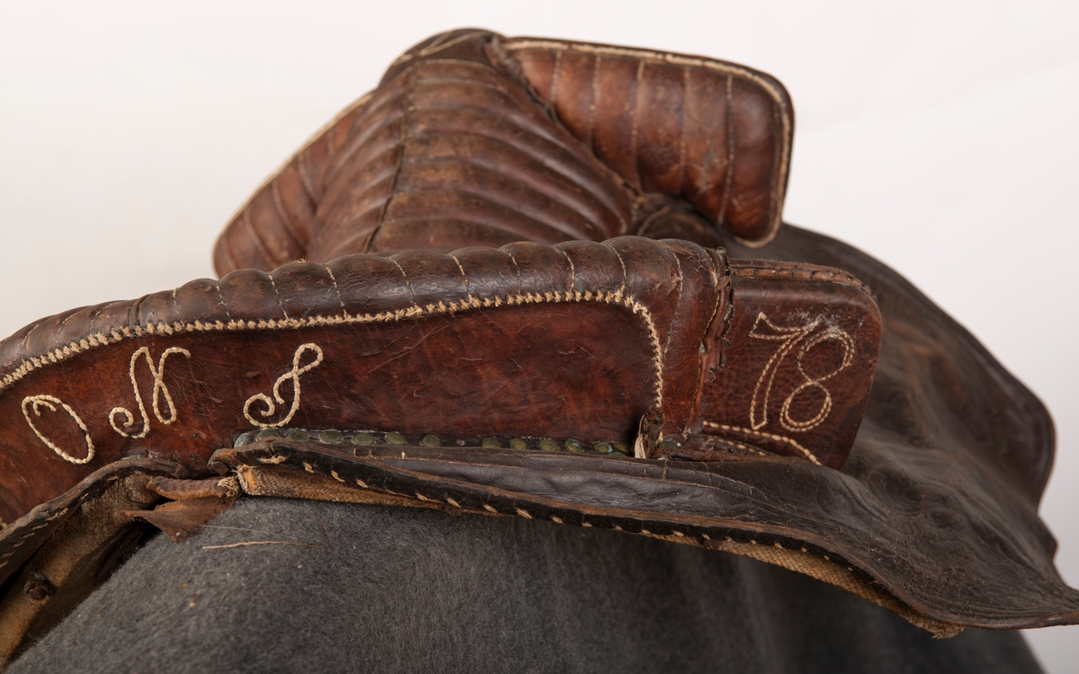 Lærtrukket sadel fra 1778. Initialene ONS brodert. Kapper med preget lær. 