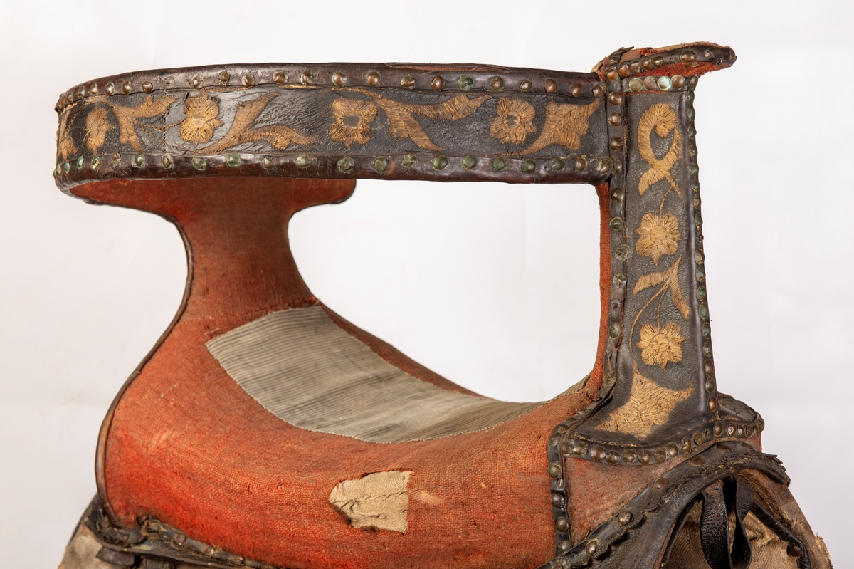 Sete av rødt ullklede reparert med stripete stoff på midten av setet. Broderte initialer EAD og 1792. Brodert lær. Mangler lærkapper.