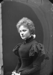 Bröstbild av Ester Grönberg i 3/4-profil. Hon är klädd i en 