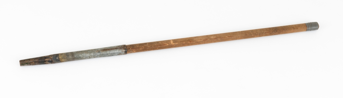 Ladestav, brukt i forbindelse med grøftesprening i skog og utmark, der man forsøkte å drenere vekk vann som virket veksthemmende på produksjonsskogen. Dette redskapet er 109,5 centimeter langt og består av en rett trestav med ovalt tverrsnitt, samt et 36 centimeter høyt sinkgalvanisert endebeslag, ei slags hylse, som omslutter den ene enden av staven. Ettersom denne delen av staven er litt kon, ser det ut til at beslaget egentlig er lagd av to komponenter med litt ulike diametere, Den øverste delen av beslaget har dessuten to sidespalter, som nok er en tilpasning til stavens noe økende tjukkelse fra ytterenden og oppover. Beslaget er forankret i trestaven ved hjelp av to gjennomgående nagler. Rundt den øvre enden av treskaftet er det viklet litt grå tape.