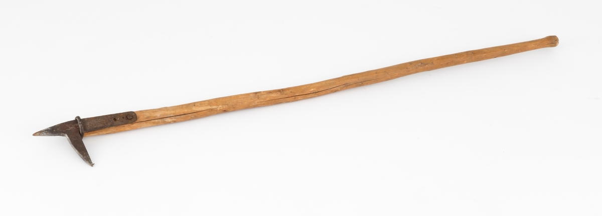Fløterhake med treskaft. Den smidde haken er 25,1 centimeter lang. Den har en cirka 14,5 centimeter lang og 3,2 centimeter bred flat tange med to gjennombrutte skrue- eller spikerhull. Tangen ligger en mot ei flattelgjet sone ved skaftets fremre ytterende. Her er det festet ved hjelp av en maskinskrue som er ført gjennom det bakre skruehullet og skaftet. Forholdet mellom den fremre delen av tangen og skaftet er stabisert ved hjelp av en smidd jernring som omslutter begge disse komponentene. I forlengelsen av tangen har fløterhaken en framoverrettet, spisst triangulær pigg - i enkelte dialekter kalt «stingar'n» - som er 7,5 centimeter lang. Denne piggen ble brukt når fløterne hadde behov for å bende løs stokker som hadde filtret seg sammen i vassdraget. Haken har også en pigg som står noenlunde vinkelrett på de hittill nevnte komponentene - i noen dialekter kalt «hoggar'n», fordi fløtere hogg denne piggen inn i yteveden på stokkene når de hadde behov for å skyve dem fra seg eller trekke dem mot seg. På dette redskapet er hoggar'n om lag 9 centimeter lang. Spissen er noe oppfliset, og ville vel blitt filt, eller oppvarmet i esse og hamret kvass igjen, dersom haken skulle brukes i praktisk fløting igjen. Skaftet er 137 centimeter langt. Der lagd av stammen fra et undertrykt, seinvokst lite grantre som er barket og overflatebehandlet med kniv. Den smidde haken er festet i rotenden av dette skaftet.