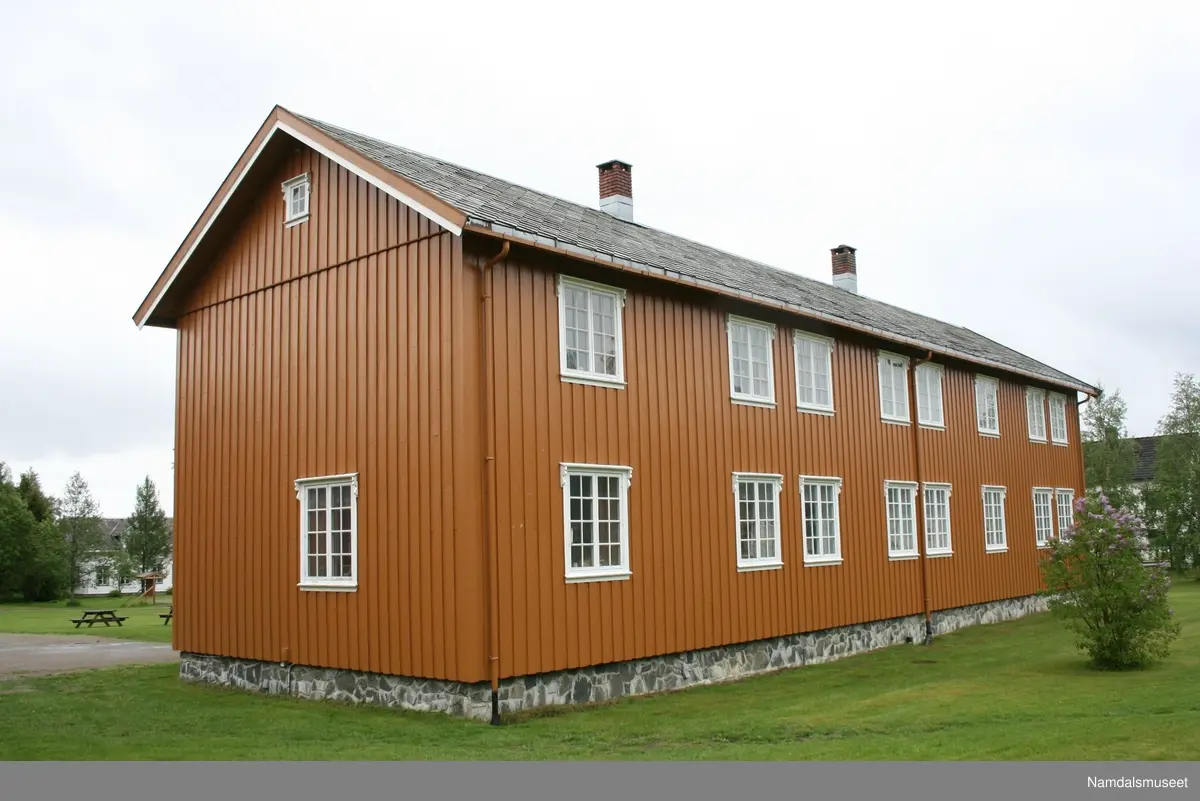 Laftet tømmer hus som står på en brannsikker kjeller i betong. Muren er forblendet over bakkenivå med skifer. Tømmermannskledning. Skifertak (Altaskifer)