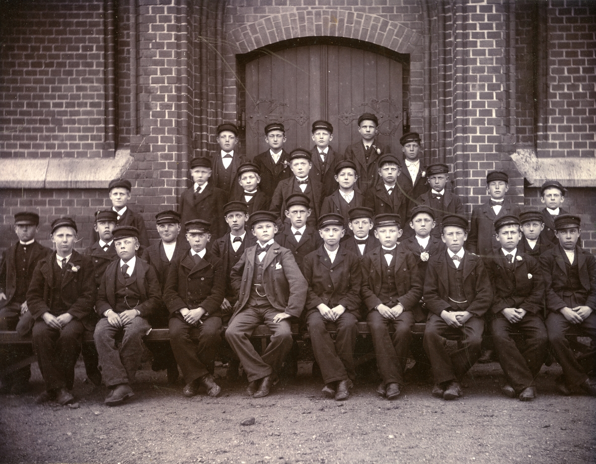 Konfirmation i Fässbergs kyrka omkring år 1900. Konfirmationspräst var Lindeberg.
Gustav Johansson, sjätte person sittande från höger sida, var farfar till givaren. Född: 1886 i Fässbergs Mellangård "Jolen". Flyttade vid 7 års ålder till Alegårdslätt, Fässberg. Gift 1917 i Kållered och bodde till sin   död 1977 i Vommedal Östergård "Olas" Kållered