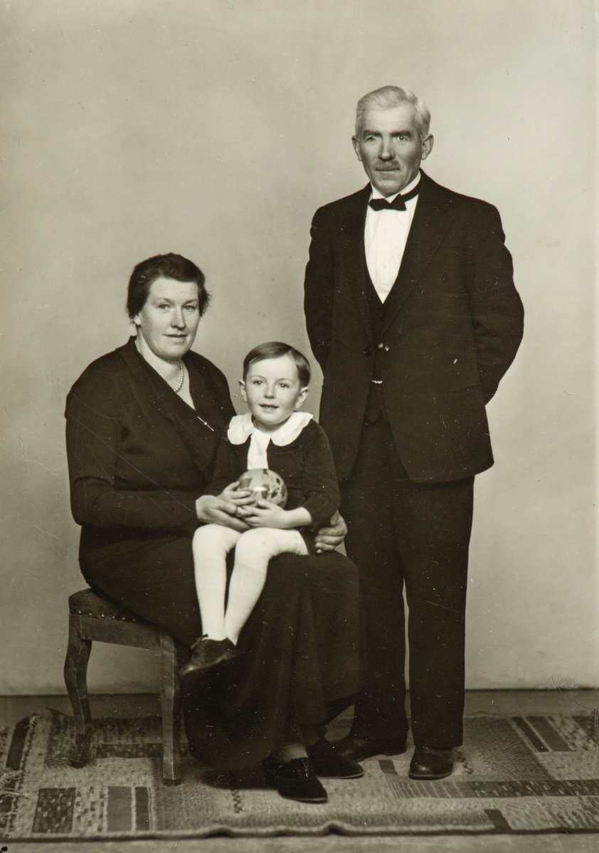 Familie gruppe 3. 
Anna Kinn-Berntsen med sønnen Ole Martin Kinn-Berntsen på fanget, Olaf Berntsen stående ved siden.  Olaf var gårdsarbeider på Staur gård. Anna jobbet som bygdekokke.