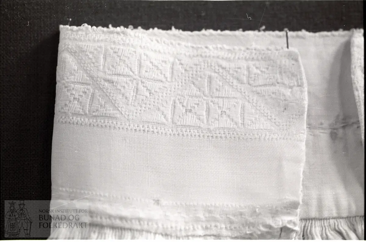 Nordhordlandsmessa nr. 92.  -  Breidde halslinning:  6 cm, breidde bord:  2,8 cm + tagger, breidde broderi langs splitten:  3,0 cm, lengde broderi langs splitten:  13,2 cm.  "frå 1872".  Splitten open heilt ned.  Framstykke og kortere bakstykke.