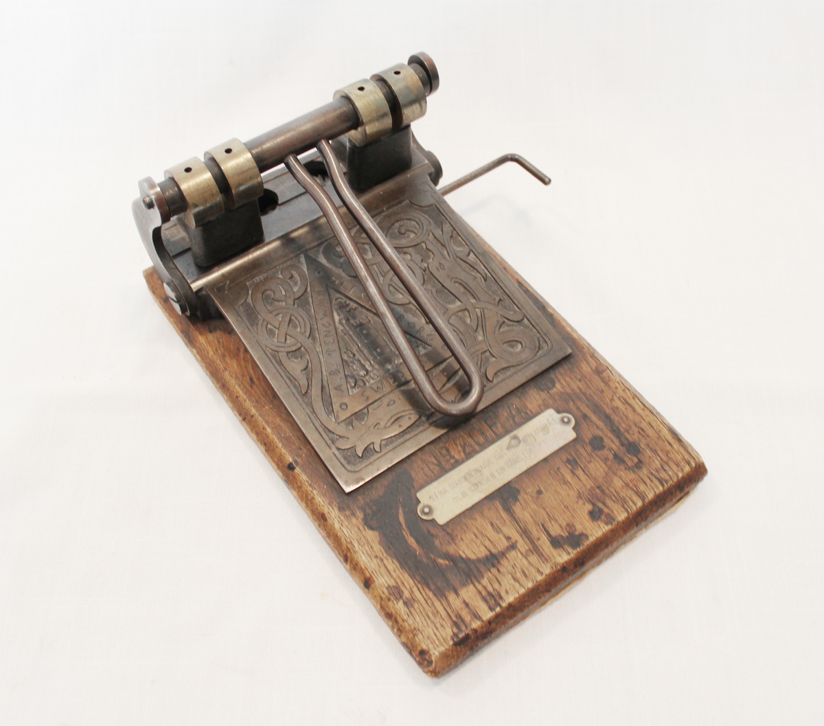 Dekorativ hullemaskin med inskripsjoner. 

En inskripsjon med føringer for vedlikehold: Befria stansen hvarje dag från pappersaffall. Olja stansen en gång i veckan. 
