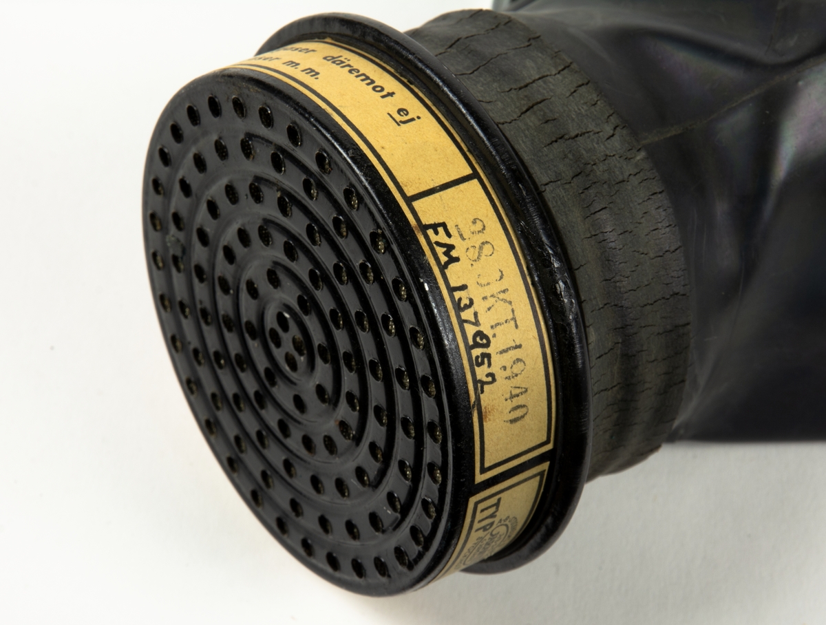 1. Gasmask med tygväska. Innehåller även instruktionsbok..
2. Gasmask av gummi med filter Typ 21.
3. Filter till gasmask, koloxidfilter M2311-721.