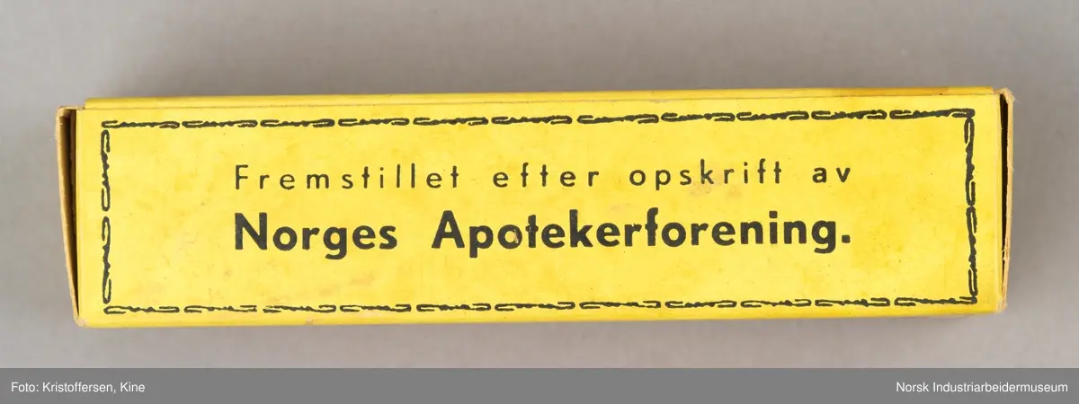 Tube med smertestillende brannsalve i original emballasje. Esken er avlang og gul med sort skrift-