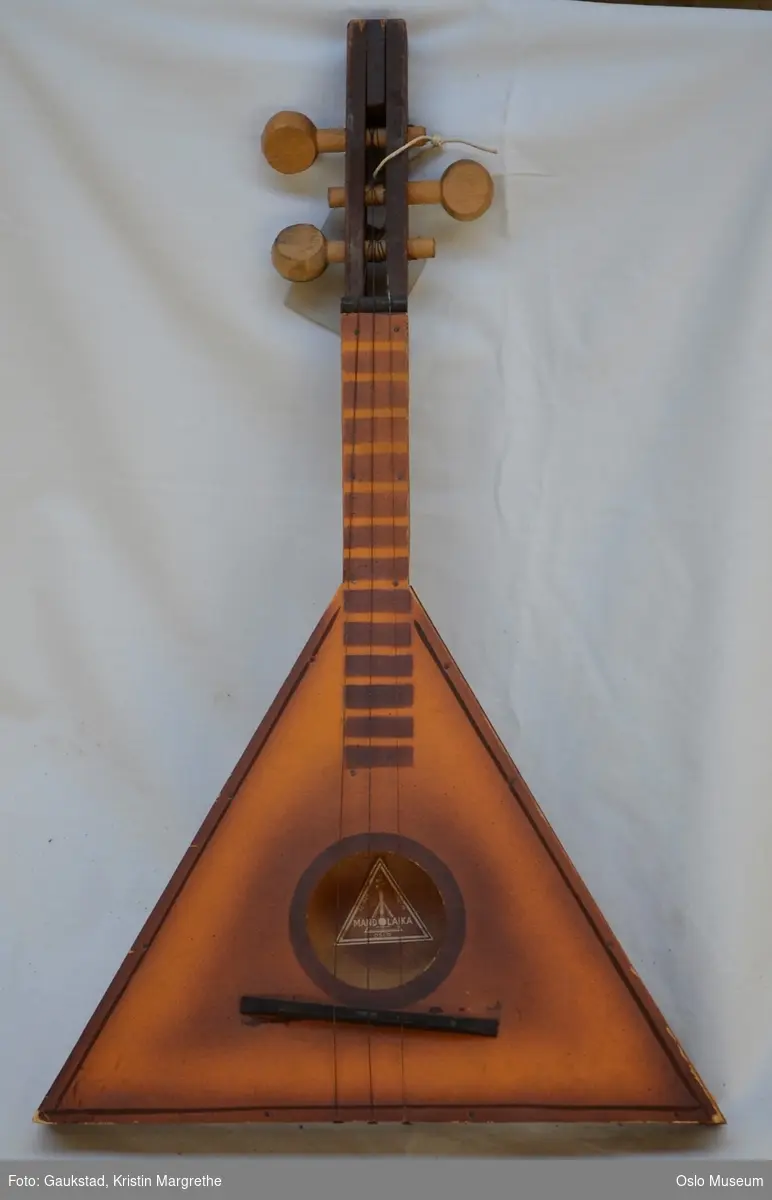 Instrument som er blanding av Mandolin og Balalaika; trekantet korpus, tre strenger, kort hals.