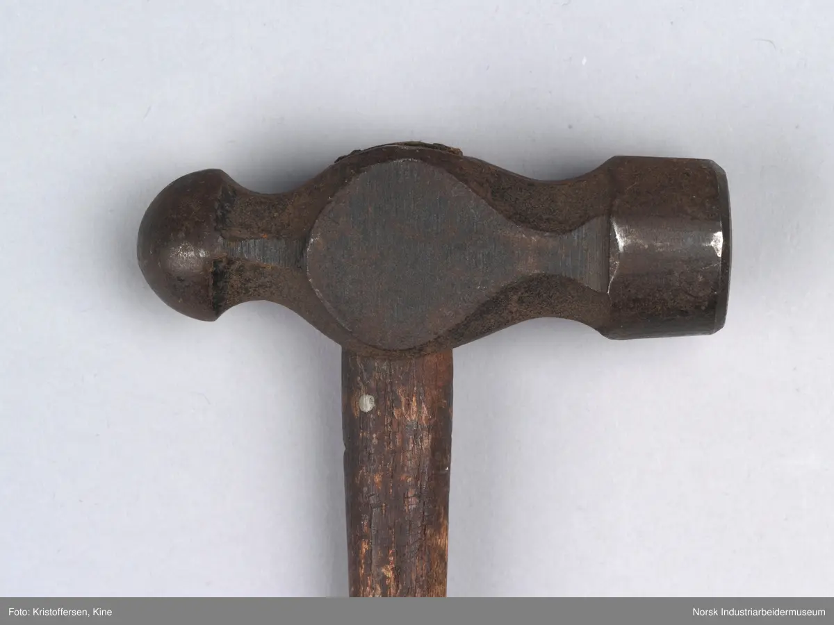 Vognvisitørhammer. Skaftet er 79 cm. langt. Skaftet er gjennomgående. Hodet er veldig svart og sitter litt slarkete. Merking: Lok. 9 er svidd inn. På hammerhodet står det: ½ lbs. Germany. Det er også et stempel i form av en stigbøyle