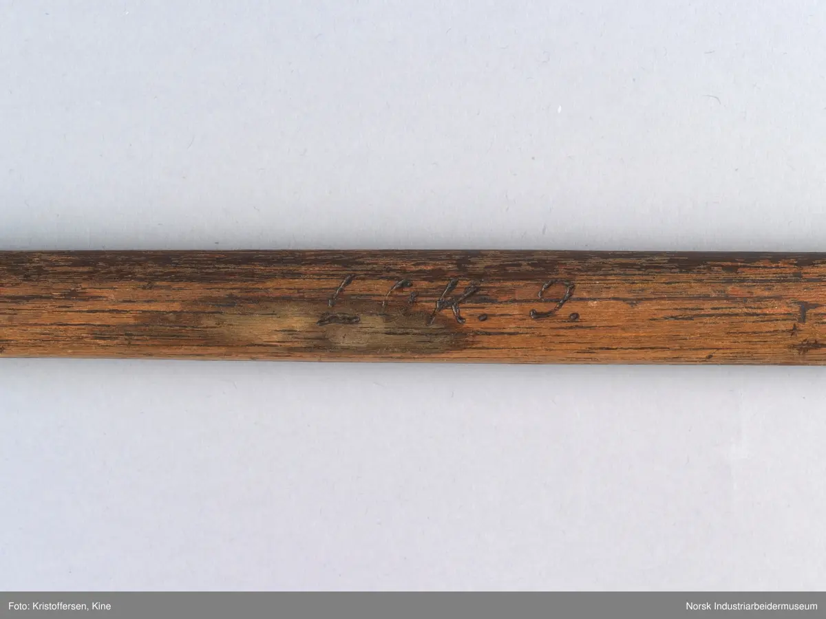 Vognvisitørhammer. Skaftet er 79 cm. langt. Skaftet er gjennomgående. Hodet er veldig svart og sitter litt slarkete. Merking: Lok. 9 er svidd inn. På hammerhodet står det: ½ lbs. Germany. Det er også et stempel i form av en stigbøyle