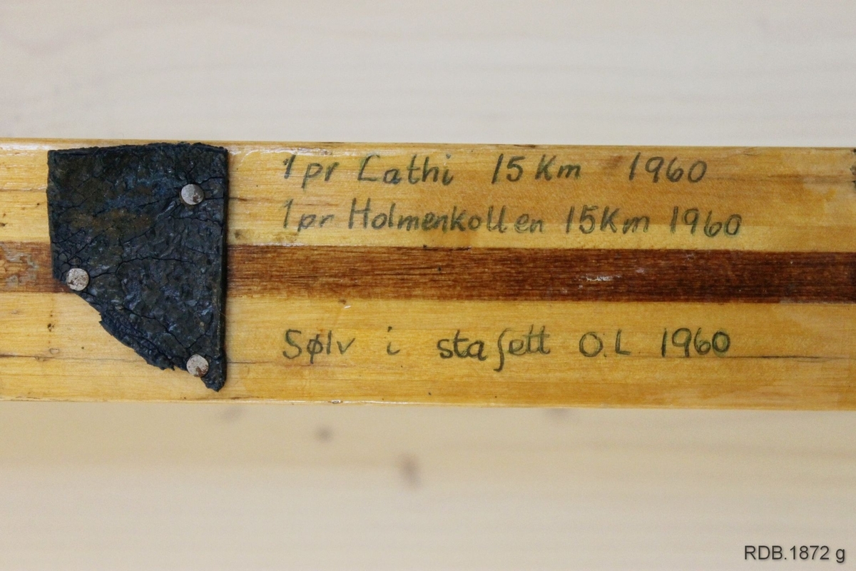 Avsmalende jevnbred ski med liten bue. Bøy uten tupp. Tilspisset brettende.
Dekorert med ei brun stripe på trehvit bunn.

Stempel fra 1960-sesongen på skiet.