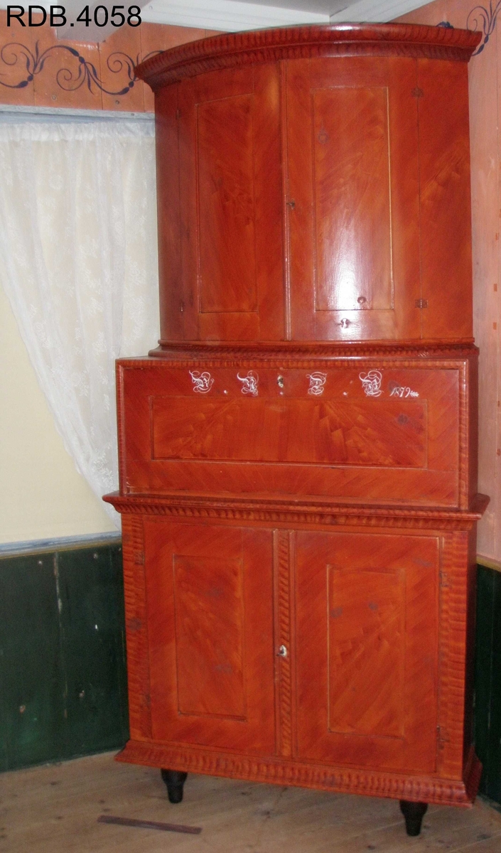 Dette er et kråskap malt i rødt. Det har tre rom, hvor det øverste og nederste er de største. Det øverste rommet har en avrundet front, og to dører. Innvendig har det en hylle, samt en rekke med 12 hakk som man kan henge skjeer osv. i. Rommet er malt med en hvit grunnfarge og noen brune flekker som er lasert på. Dørenes innside er rosa. Det midterste rommet er minst. Det har en firkantet front, og også fremste del av sidene er firkantet. Det har en dør som er hengslet i nerkant. Når den åpnes, faller fren framover og blir som et bord. På utsiden av denne døra er det påskrevet dette; RNDB 1879. RNDB står for Rannei Nilsdatter Bjørnstad. Det midterste rommet er trehvitt, men døras innside er malt rosa. Det nederste rommet har en firkantet front og firkantede sider helt fremst. Rommet har en hylle. Den er trehvit, men kanten på fronten av den, er malt med samme lasering som skapet ellers. Rommet har to skapdører som slås utover. Innsiden av skapdørene er rosa, mens resten av rommet er trehvitt. Alle tre rommene har nøkkellås i dørene, og alle tre nøklene eksisterer fortsatt på kråskåpen. Skapet står på tre føtter; to i front og en i bakerste hjørne.Skapet er lasert med en brunrød farge.