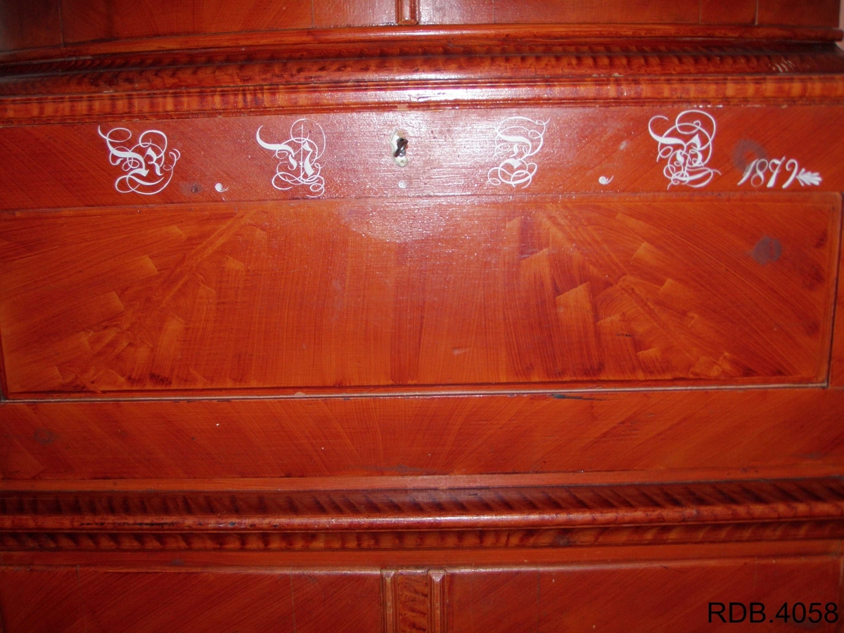 Dette er et kråskap malt i rødt. Det har tre rom, hvor det øverste og nederste er de største. Det øverste rommet har en avrundet front, og to dører. Innvendig har det en hylle, samt en rekke med 12 hakk som man kan henge skjeer osv. i. Rommet er malt med en hvit grunnfarge og noen brune flekker som er lasert på. Dørenes innside er rosa. Det midterste rommet er minst. Det har en firkantet front, og også fremste del av sidene er firkantet. Det har en dør som er hengslet i nerkant. Når den åpnes, faller fren framover og blir som et bord. På utsiden av denne døra er det påskrevet dette; RNDB 1879. RNDB står for Rannei Nilsdatter Bjørnstad. Det midterste rommet er trehvitt, men døras innside er malt rosa. Det nederste rommet har en firkantet front og firkantede sider helt fremst. Rommet har en hylle. Den er trehvit, men kanten på fronten av den, er malt med samme lasering som skapet ellers. Rommet har to skapdører som slås utover. Innsiden av skapdørene er rosa, mens resten av rommet er trehvitt. Alle tre rommene har nøkkellås i dørene, og alle tre nøklene eksisterer fortsatt på kråskåpen. Skapet står på tre føtter; to i front og en i bakerste hjørne.Skapet er lasert med en brunrød farge.