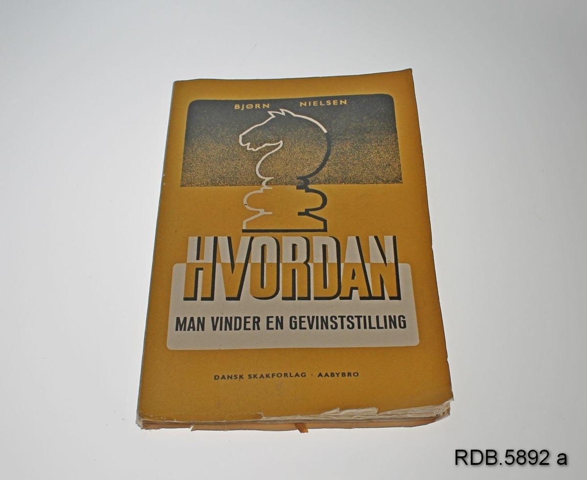 Uinnbundet bok "Hvordan man vinder en gevinststilling". Gul, svart og hvit forside med sjakk-hest.
